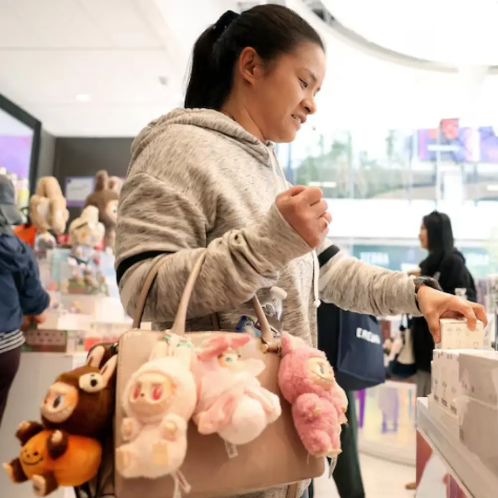 Cliente en train de découvrir une boutique POP MART, sac rempli de peluches Labubu et Skullpanda